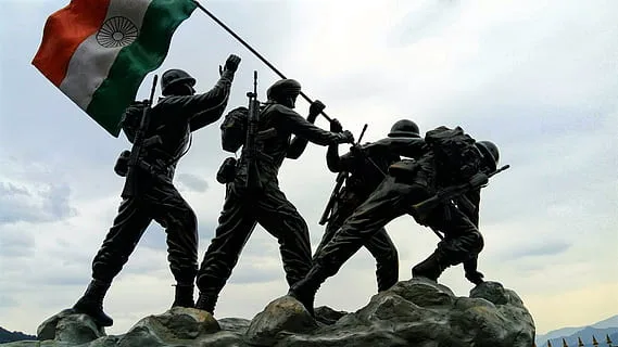 indian flag being carried by statues of indian soldiers