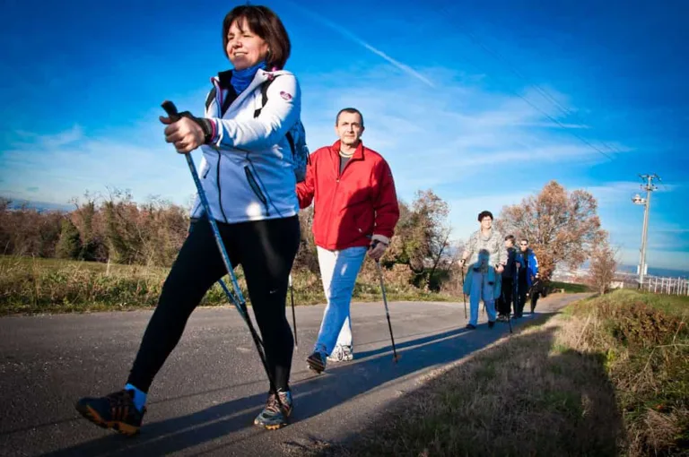 a few people walking on the street with sticks